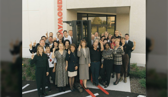 Employees in a group photo outside the Carol Stream office with a forklift