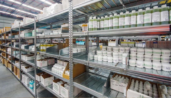 Warehouse shelves stocked with various bottles, containers, and packages