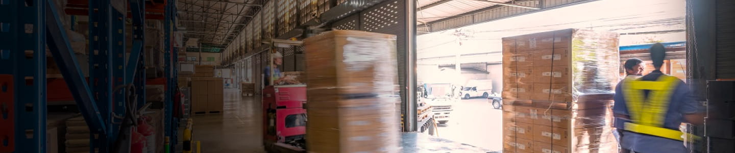 Warehouse dock view from the inside. A forklift moves towards the open dock.
