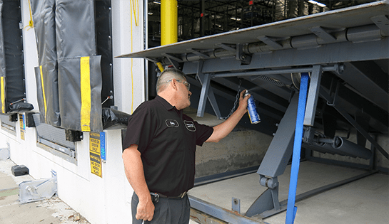 A technician works on a dock leveler