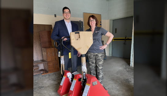 Ben Dymit and Jenni Oliva stand behind donated pallet jacks