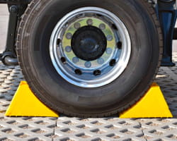 Wheel chocks are set on both the front and back side of a tire