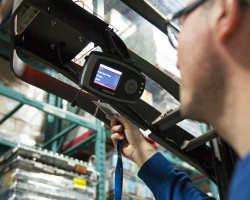 Telematics system installed on a forklift. An operator scans his ID badge just below the device.